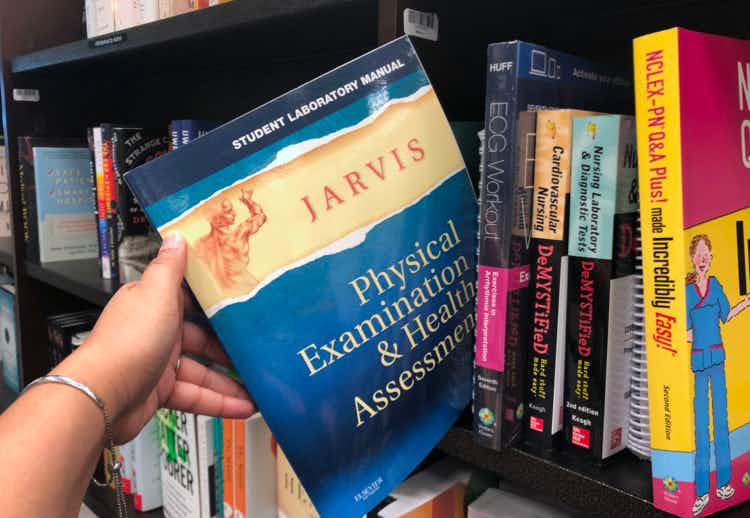 Hand pulling out a college lab manual on a Barnes & Noble shelf