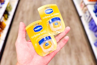 person holding 2 vaseline lip therapy balms in an aisle