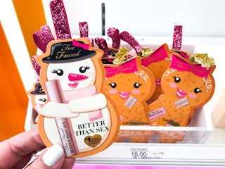 Someone picking up a Too Faced Better Than Sex Limited Edition Mascara Ornament from a shelf at Target