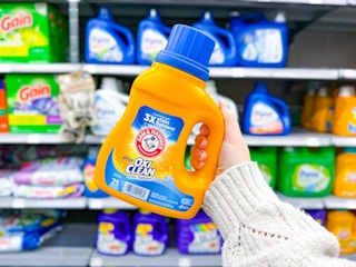 Arm & Hammer + Oxi Clean Laundry Detergent (25 load bottle) held up in center aisle at Walmart