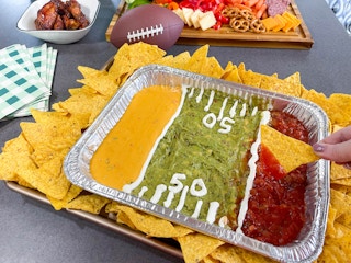 a tray of dips made into a football field