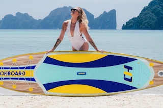 a woman using a stand up paddleboard