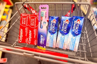 colgate and crest toothpaste with an oral-b toothbrush in a cart