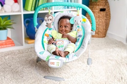 Lifestyle image of the Bright Start Jungle Baby Bouncer (on carpeted floor in room setting)