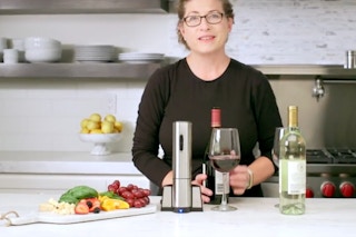 a woman presenting the Cuisinart Electric Wine Opener in a kitchen