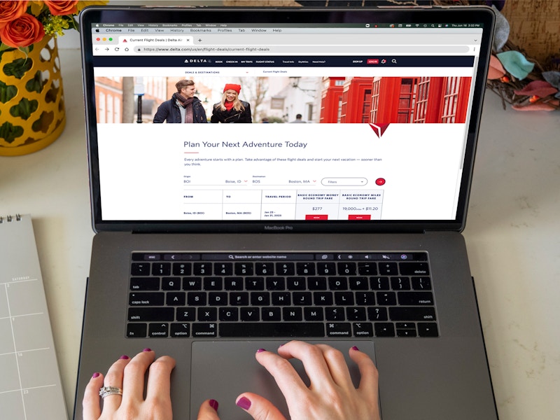 person browsing delta flight deals on macbook laptop