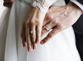 Two couples showing off their wedding rings