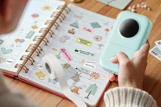 a label maker machine near a notebook