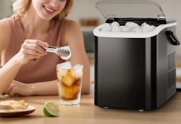 person adding ice to her drink from the ice maker