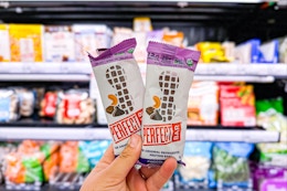 hand holding 2 perfect bars in front of produce at target