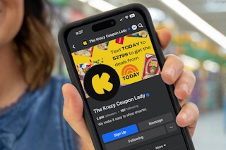 someone holding up a phone displaying the KCL facebook page