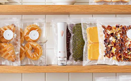 a vacuum sealer with vacuum-sealed food on a shelf