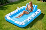 Lifestyle image of an inflatable sunbathing lounger used outdoors in the grass