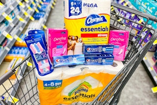 pack of toilet paper, paper towels, two packs of liners and razors, and three toothpastes on store aisle floor