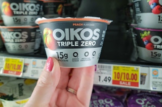 hand holding dannon oikos triple zero yogurt cup