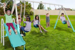 lifestyle image of children playing on a swingset
