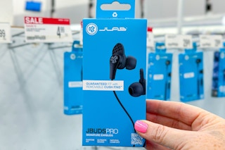 person holding a pack of jlab ear buds