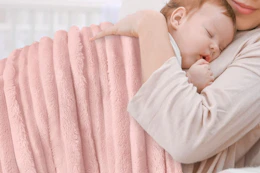 a woman holding a baby in a blanket