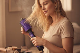 a woman blow drying her hair