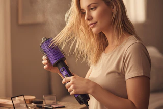 a woman blow drying her hair