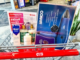 cvs cart with crest gum toothpaste, sheadmoisture and olaplex shampoo, and a conair hair dryer in it with a cvs epic beauty flyer