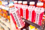 hand holding bodyarmor drink next to store shelf