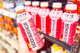 hand holding bodyarmor drink next to store shelf