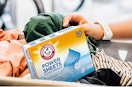 a box of laundry detergent sheets in a basket of laundry