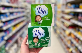 hand holding two boxes of puffs tissues at the store
