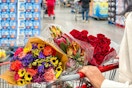 someone pushing a cart of flowers at costco