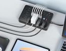 a flat surge protector with plugs next to a laptop and tablet