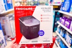 hand holding a frigidaire-ice-maker resting on target cart in aisle