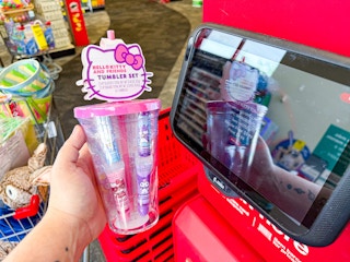 person holding a hello kitty tumbler by a price scanner