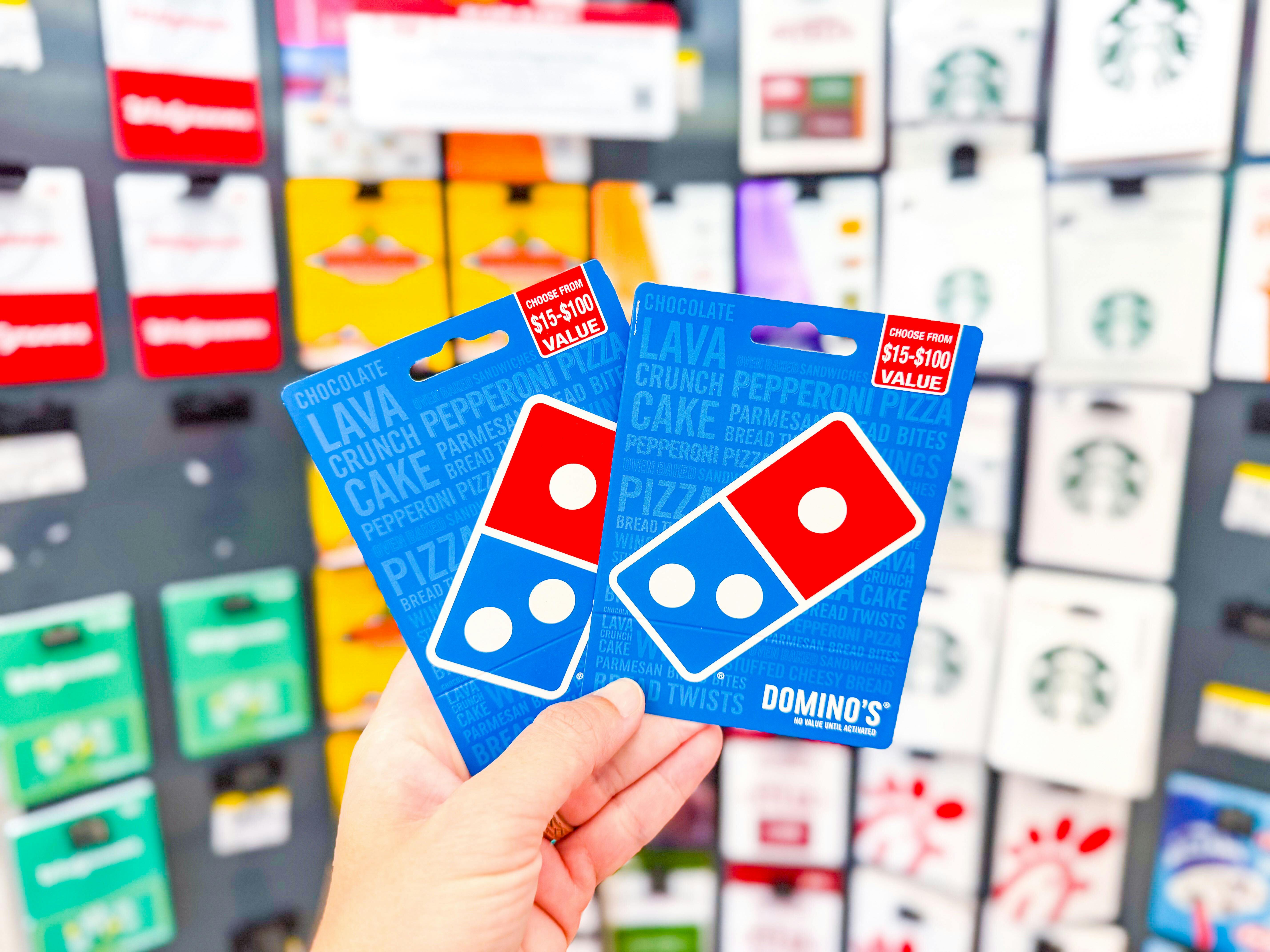 hand holding dominos gift cards