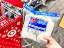 hand holding a 12-pack of hanes socks in front of target cart
