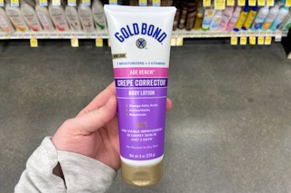 hand holding a bottle of gold bond age renew crepe corrector lotion