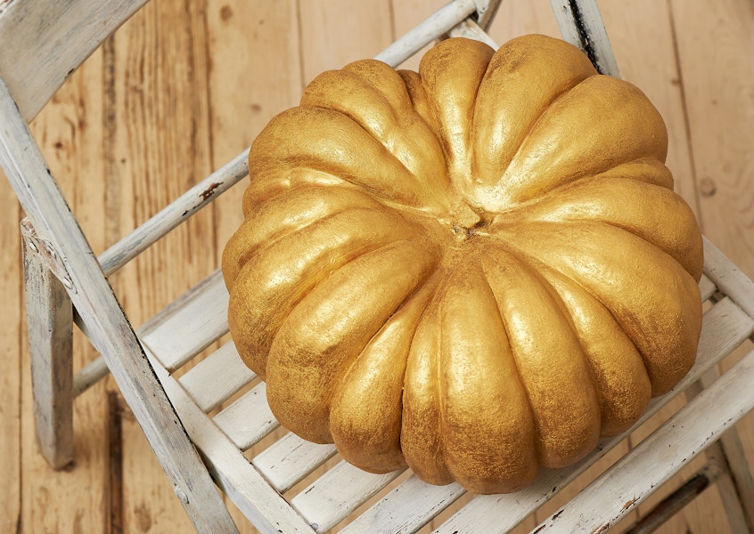 pumpkin painted with gold acrylic paint on chair