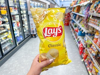 hand holding lay's classic chips in walgreens