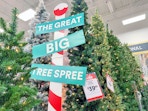 Christmas trees on display at Michaels with a sign that reads, "The Great Big Tree Spree"