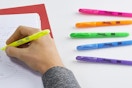 a person highlighting a piece of paper with colorful Sharpies
