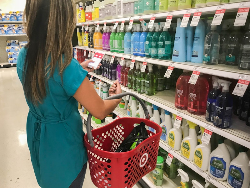 woman in Target shopping for hand soap with app and basket