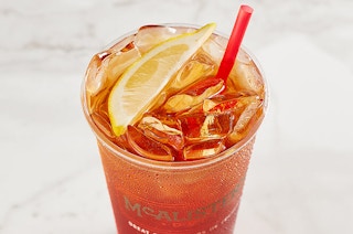 A cup of tea from McAlisters against a white table.