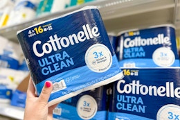 person grabbing a pack of cottonelle toilet paper from the shelf