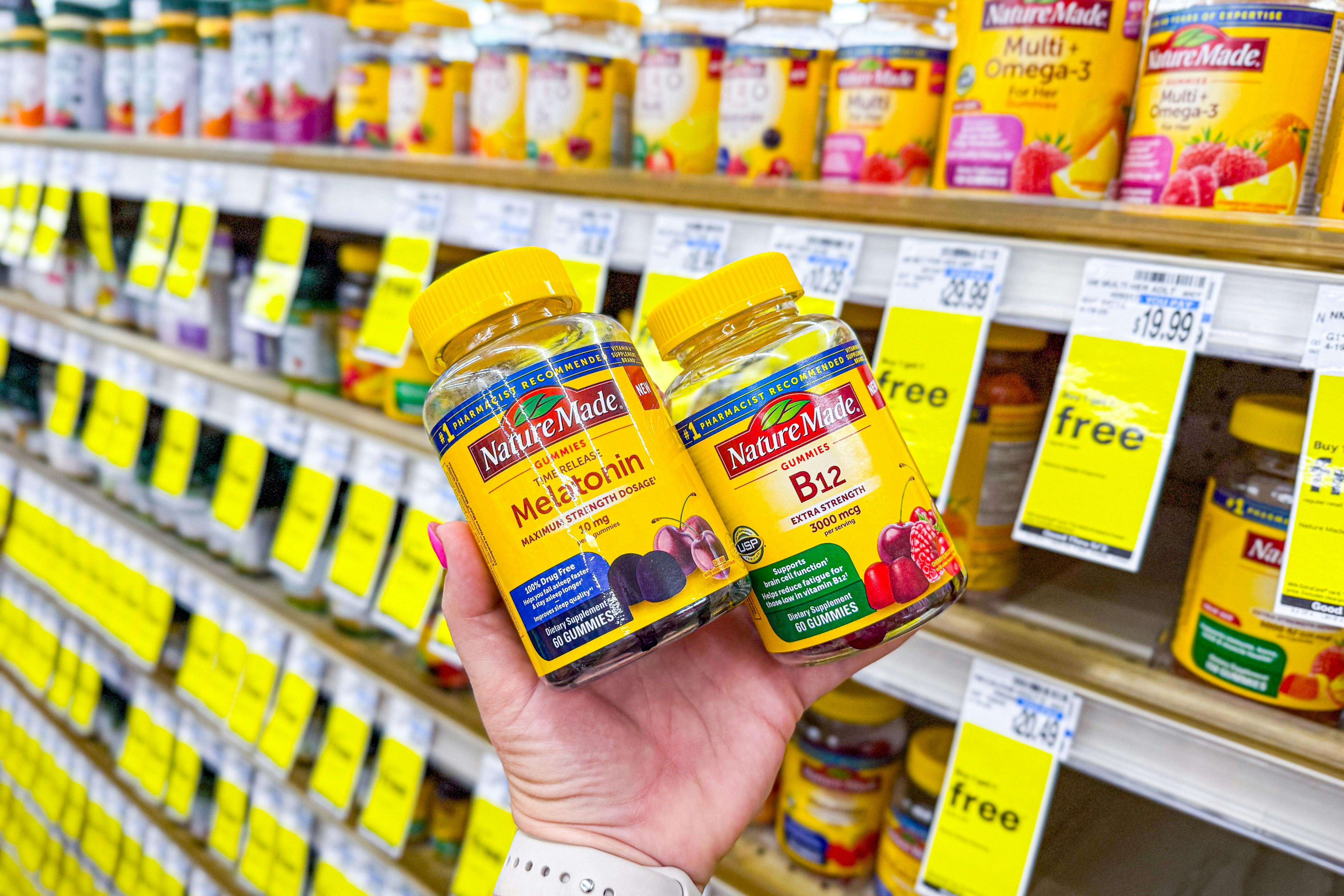 person holding 2 bottles of nature made vitamins