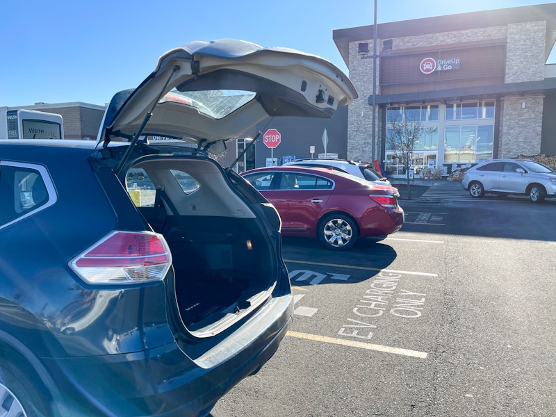 A vehicle parked with their drunk open in front of the "Drive up & go" store entrance at Albertsonsons.