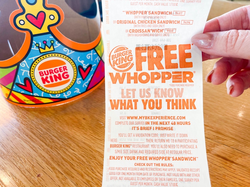 a burger king receipt being held up in front of kids crown