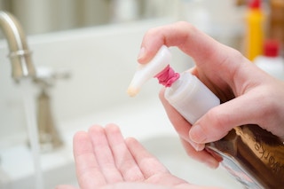 person pumping hand soap with rubber band to control flow