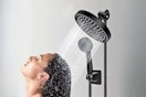 Lifestyle image of a black rain shower head being used to rinse hair