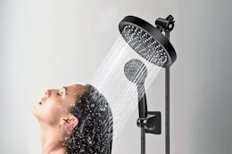 Lifestyle image of a black rain shower head being used to rinse hair