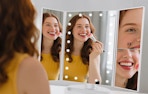 a person doing their makeup in a tri-fold mirror